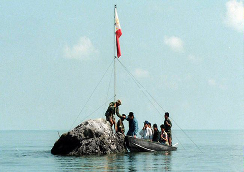 Hải quân và các nghị sĩ Philippines cắm quốc kỳ trên một mỏm đá nhỏ thuộc bãi cạn tranh chấp với Trung Quốc Scarborough/Hoàng Nham năm 1997.